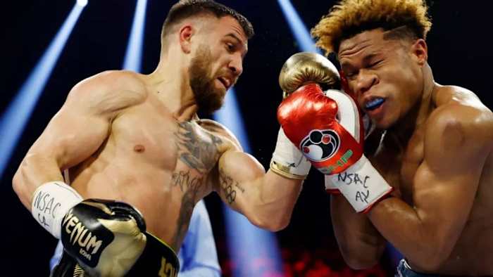 Devin Haney exchanges punches with Vasyl Lomachenko(L) during their undisputed lightweight title bout at MGM Grand Garden Arena in Las Vegas, Nevada. Jorge Linares gives his pick to have Vasily Lomachenko battle George Kambosos Jr. on May 12 at the RAC Arena in Perth, Australia. SARAH STIER/GETTY IMAGES.